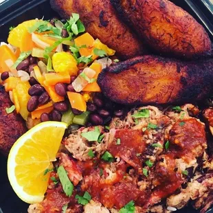 Sea island platter with Coca-Cola, barbecue, pulled pork, plantains, coconut, rice, citrus beans
