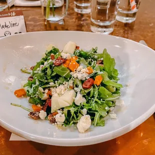 a plate of salad on a wooden table