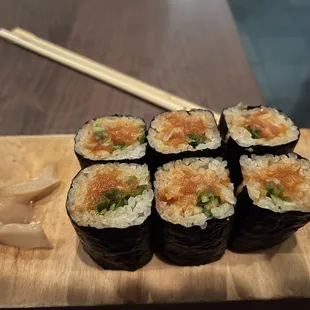 sushi rolls on a cutting board with chopsticks