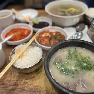 a bowl of soup with chopsticks