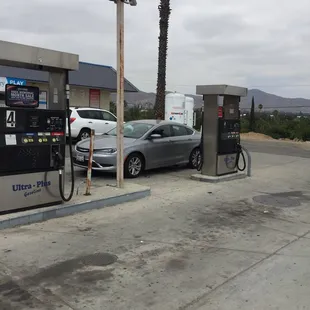 a gas pump and a car at a gas station
