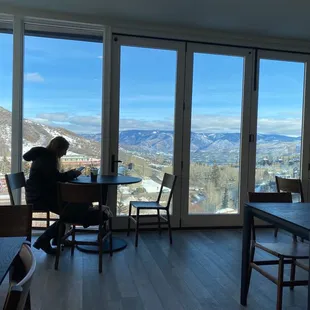 a woman sitting at a table looking out a window