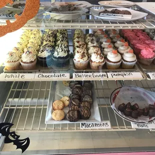 a variety of cupcakes in a display case
