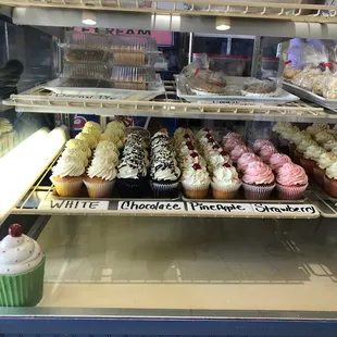 a variety of cupcakes in a display case