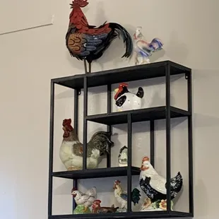 a shelf with chicken figurines on it