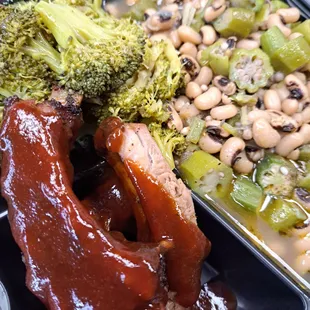a plate of meat, beans, and broccoli