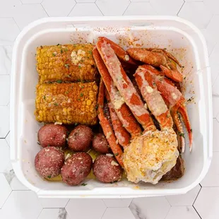 crab legs, corn, potatoes and corn on the cob