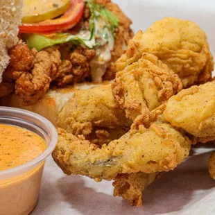 a sandwich with fried chicken and dipping sauce