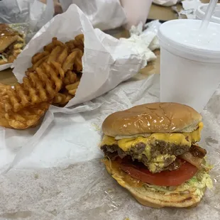 Double bacon cheese burger with everything on it (lettuce, tomato, pickles, ketchup &amp; mustard) with Waffle fries