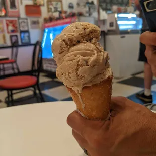 a hand holding a cone of ice cream