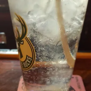 a glass of water with ice and a straw