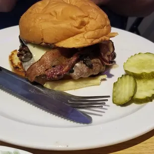 a burger and pickles on a plate