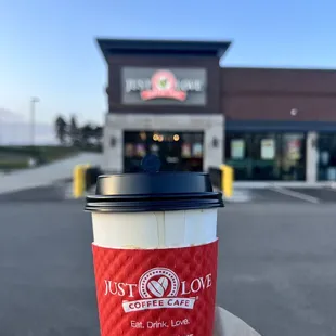 a hand holding a coffee cup