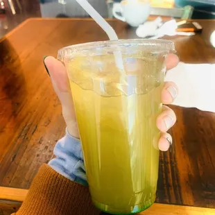 a person holding a cup of green tea