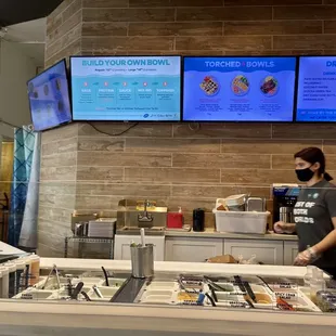 a woman wearing a face mask behind a counter