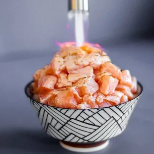 a bowl of food with chopsticks sticking out of it