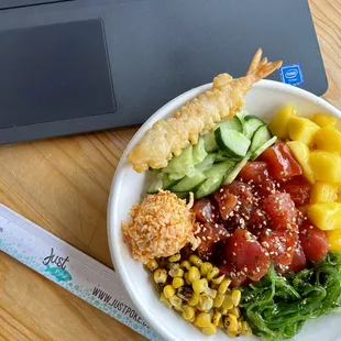 a bowl of food next to a laptop