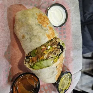 Burrito with spicy salsa mild salsa and sour cream.
