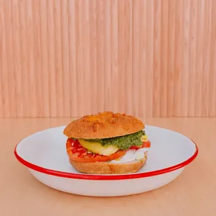 The Jimmy Pesto breakfast sandwich Cheese bagel with plain schmear, house made pesto, a slice of tomato and folded just egg.