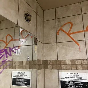 a bathroom with graffiti on the walls
