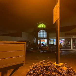 a neon sign in a parking lot