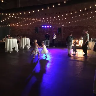 a little girl dancing at a wedding