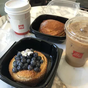 Iced oatmilk latte, blueberry croissant and chicken sausage/egg calzone