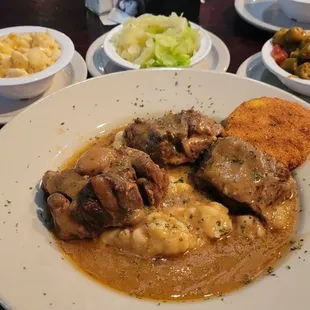 Oxtail with mashed potatoes. Mac n cheese and cabbage sides