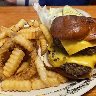 Double cheeseburger on a pretzel bun with fries and rings