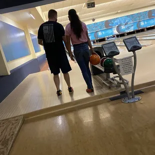 Dad giving his daughter some tips for not getting gutter balls
