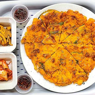 a tray of food including a pizza and fries