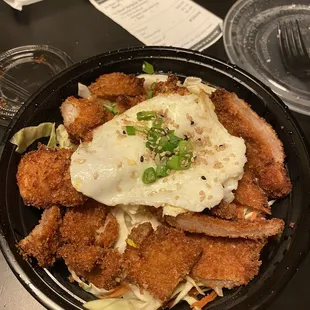 a bowl of fried chicken with a fried egg on top