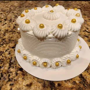 a white cake with gold pearls