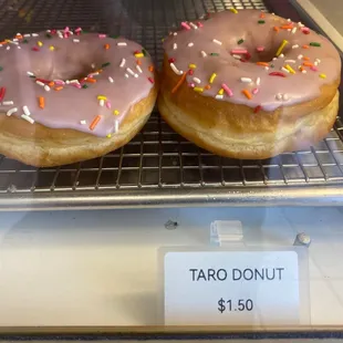 three glazed donuts with pink icing and sprinkles