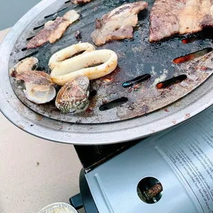 Grilling some garlic butter clams, calamari rings, etc