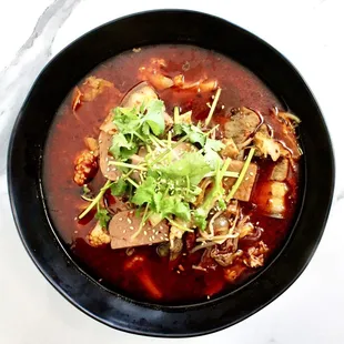 a bowl of soup with meat and vegetables
