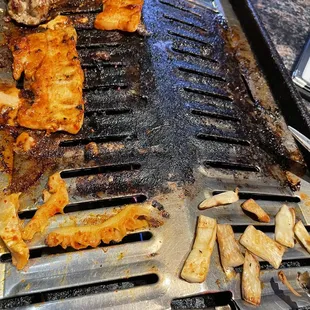 a grill with meat and vegetables on it