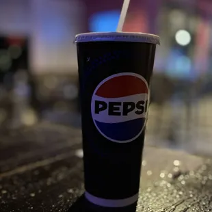 a pepsi cup with a straw