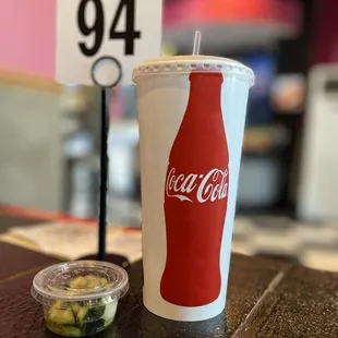 a coca cola cup and pickles