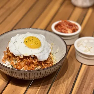 a bowl of noodles with a fried egg on top
