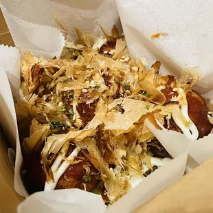 a hot dog with toppings in a box