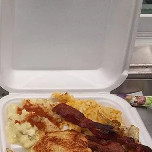 a sandwich and bacon in a styrofoam container