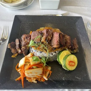 Steak Korean Style with Kim Chee, tempura Zucchini and wild rice.