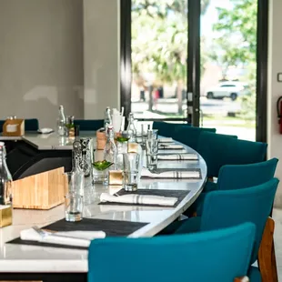 a long dining table with blue chairs
