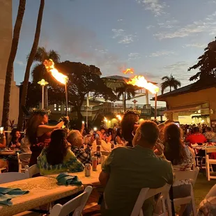 people sitting at tables with torches