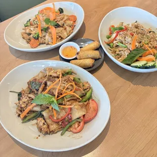 Pad see ew (top left), vegetable rolls (center), Thai basil fried rice (top right), pad kee maw (bottom left).