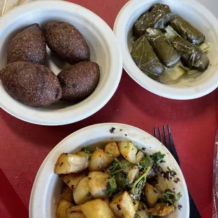 Kibbeh with a side of grape leaves and spicy lemon fried potatoes .
