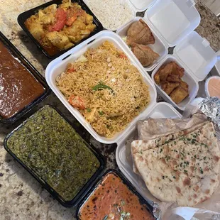 Saag Paneer, Chicken Tikka Masala, Aloo Gobi, Lamb Curry, Garlic Naan, Vegetable Samosas, and Paneer Pakora.