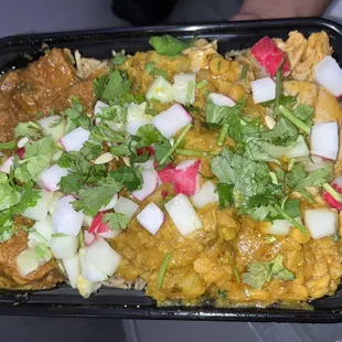 Beef curry &amp; butter chicken w lentils over veggie rice. Topped with cucumber, cilantro, &amp; radishes.