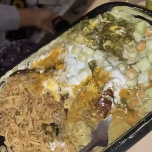 Rice with chicken curry and chick peas and cucumbers  and a ton of sauce